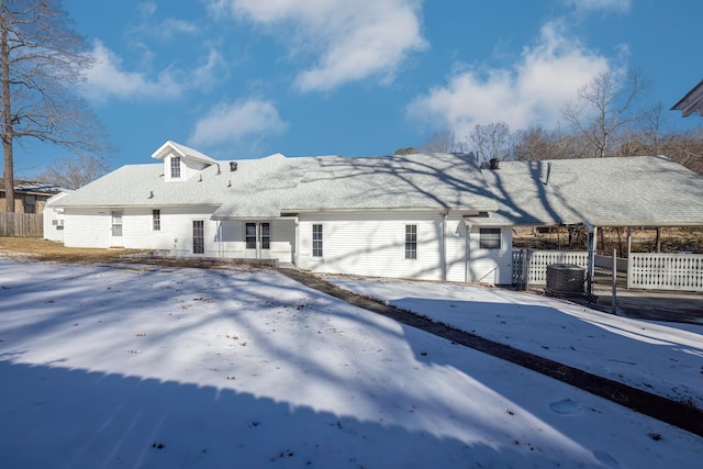 view of snow covered back of property