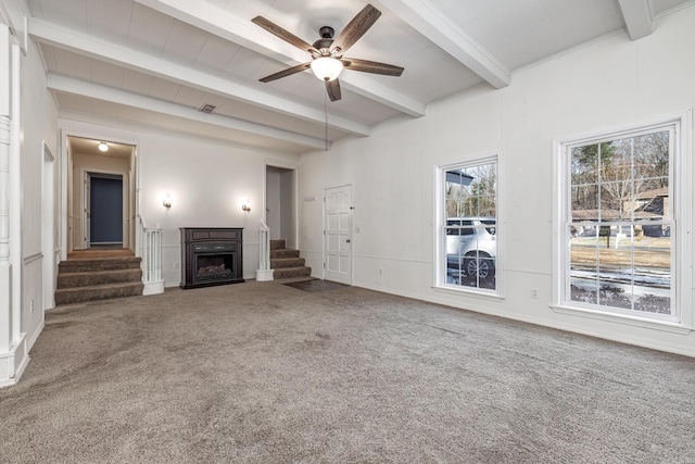 unfurnished living room with ceiling fan, carpet, and beamed ceiling