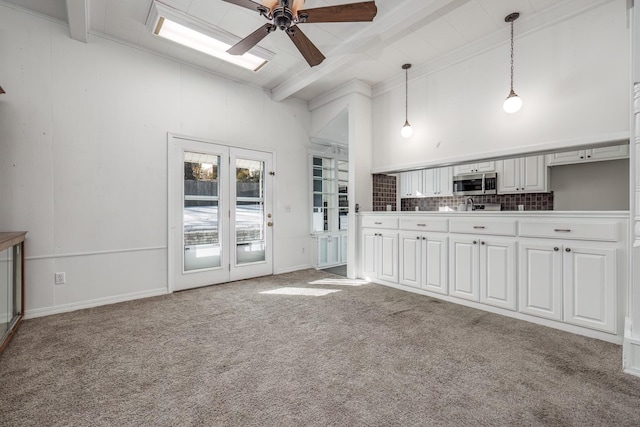 kitchen featuring hanging light fixtures, white cabinets, beamed ceiling, and high vaulted ceiling