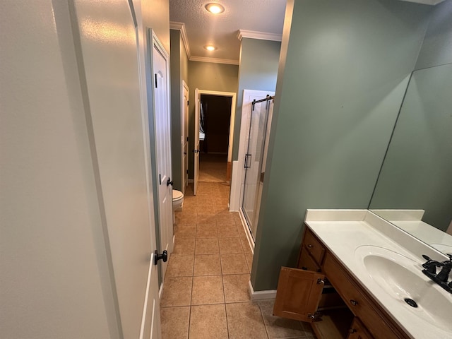 bathroom featuring tile patterned floors, toilet, crown molding, a textured ceiling, and vanity