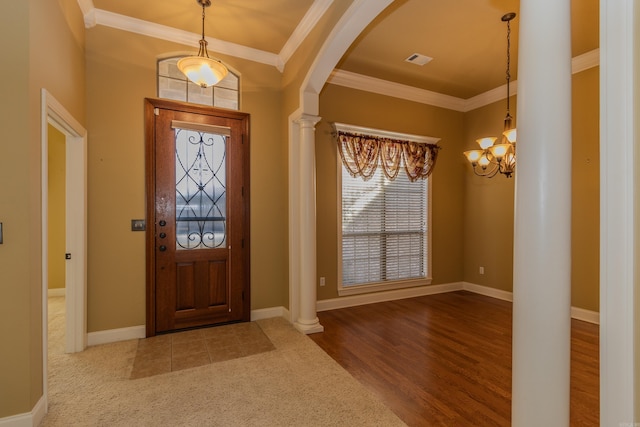 foyer featuring decorative columns, crown molding, a notable chandelier, and light hardwood / wood-style floors