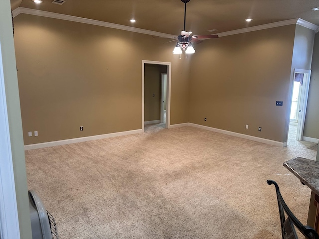 empty room with light carpet, crown molding, and ceiling fan