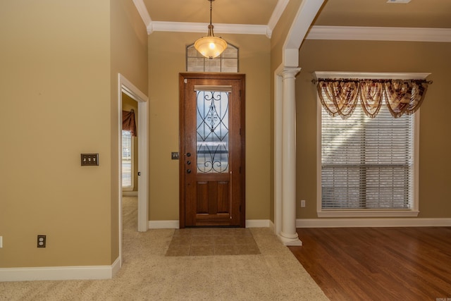 carpeted foyer entrance with crown molding and ornate columns