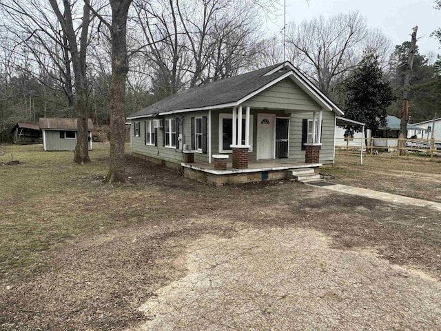 view of front of house with a porch and a shed