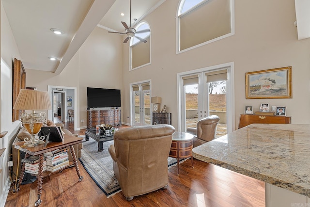 living room featuring ceiling fan, a high ceiling, dark hardwood / wood-style floors, and french doors