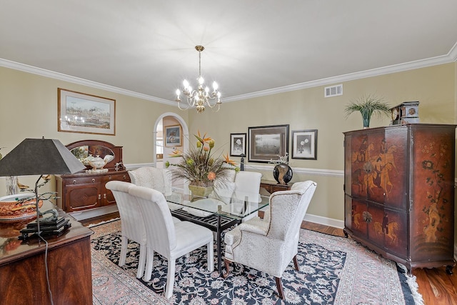 dining space featuring a chandelier, light wood-type flooring, and ornamental molding