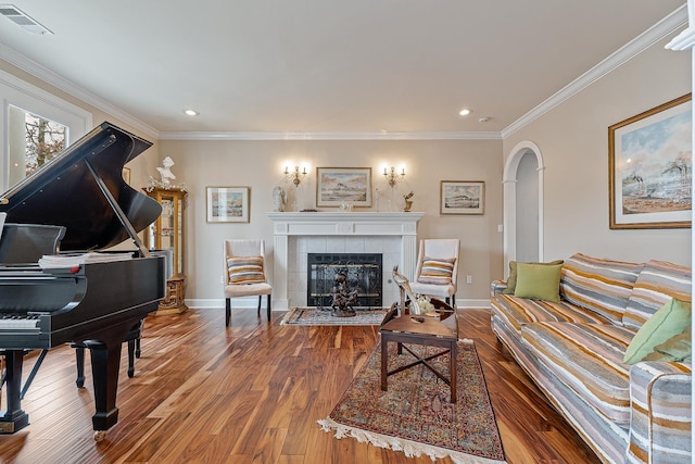 living room with a fireplace, ornamental molding, and hardwood / wood-style flooring