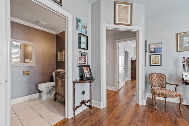 hallway featuring crown molding and light hardwood / wood-style floors