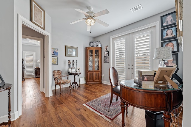 office with ceiling fan, french doors, and dark wood-type flooring