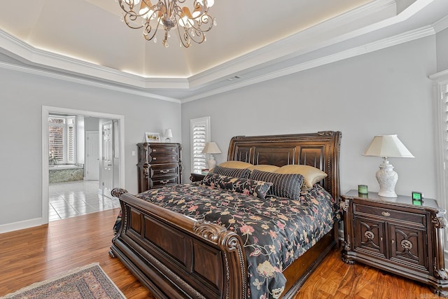 bedroom featuring a chandelier, crown molding, light hardwood / wood-style flooring, and a raised ceiling