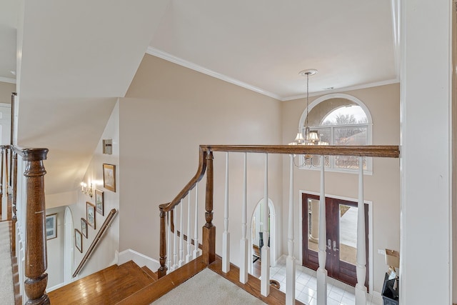 stairs featuring an inviting chandelier, ornamental molding, and french doors