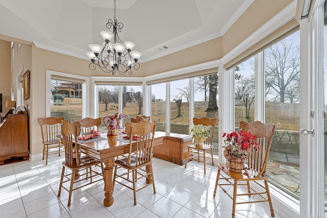 dining space with light tile patterned floors, a tray ceiling, a chandelier, and ornamental molding