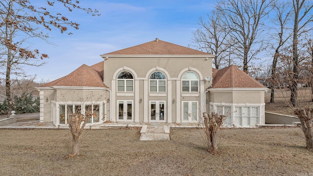 rear view of house featuring a lawn and french doors