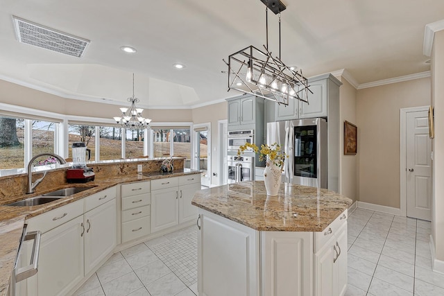 kitchen with hanging light fixtures, appliances with stainless steel finishes, sink, and a center island