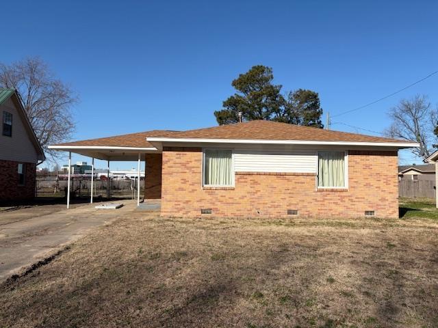 rear view of property with a yard and a carport