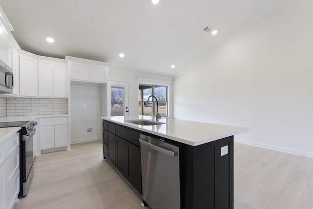 kitchen featuring dishwasher, white cabinetry, sink, a kitchen island with sink, and range with electric cooktop