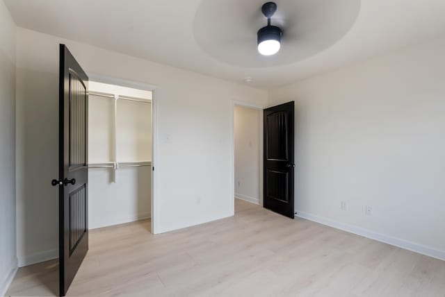 unfurnished bedroom featuring a closet, light hardwood / wood-style floors, and ceiling fan