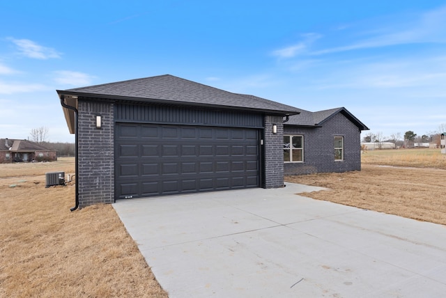 view of front of property with central AC unit and a garage