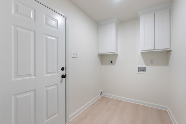 laundry area with light wood-type flooring, hookup for an electric dryer, hookup for a washing machine, and cabinets