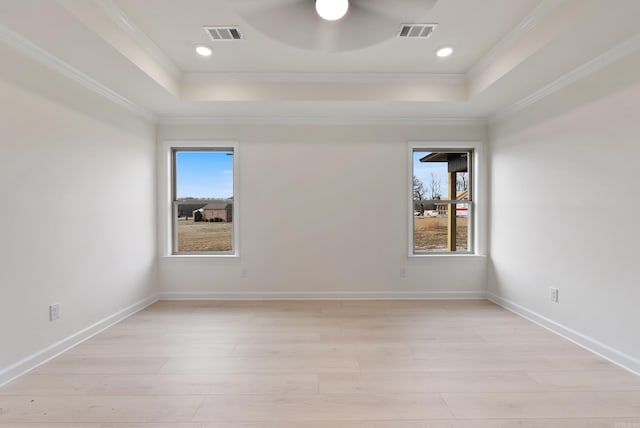 empty room featuring ceiling fan, light hardwood / wood-style flooring, a raised ceiling, and ornamental molding