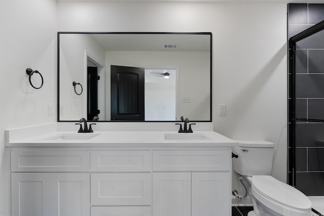 bathroom featuring toilet, vanity, and a shower