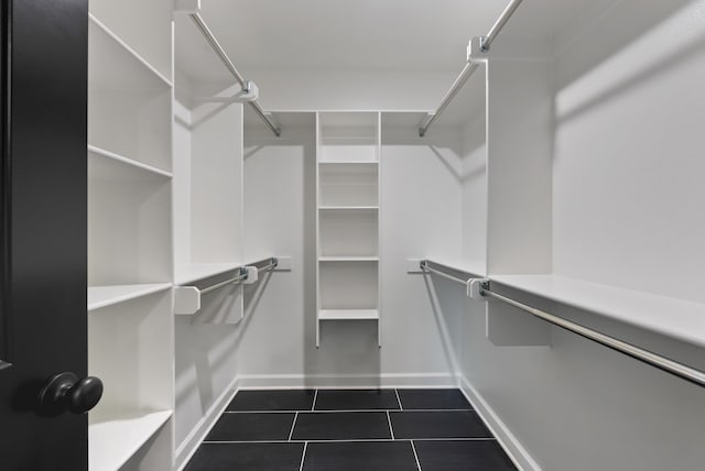 walk in closet featuring dark tile patterned floors