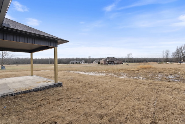 view of yard featuring a rural view and a patio area