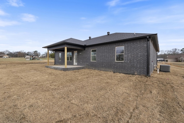 back of property with a lawn and a patio