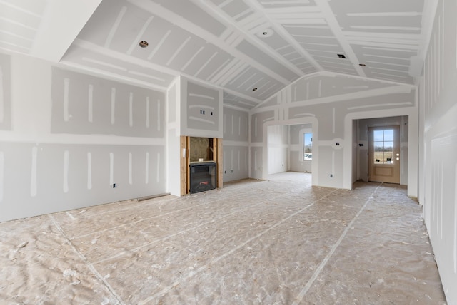 unfurnished living room featuring vaulted ceiling