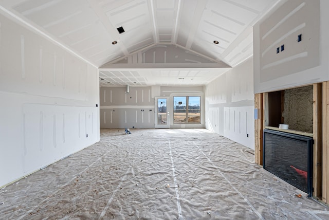 unfurnished living room featuring vaulted ceiling