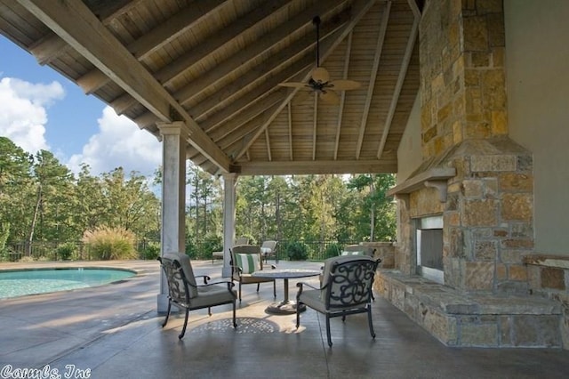 view of patio with ceiling fan, a gazebo, and an outdoor stone fireplace