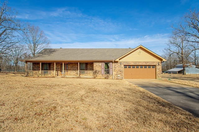 single story home featuring a front yard, a porch, and a garage