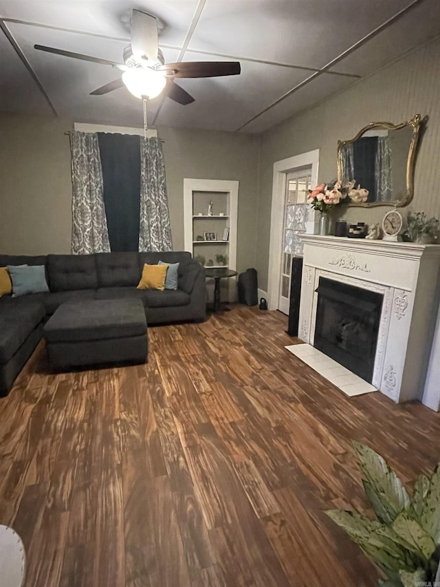 living room with ceiling fan, built in features, and wood-type flooring