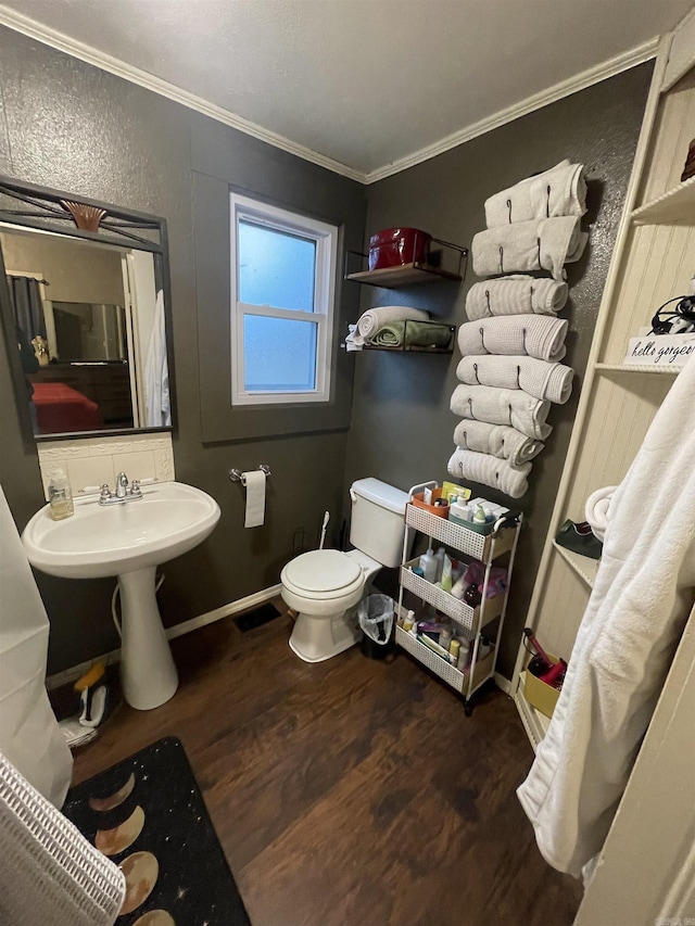 bathroom featuring toilet, backsplash, ornamental molding, and hardwood / wood-style flooring