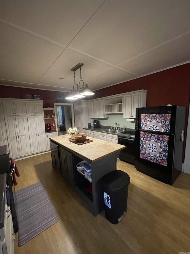 kitchen with dishwasher, white cabinets, hanging light fixtures, light hardwood / wood-style flooring, and a center island