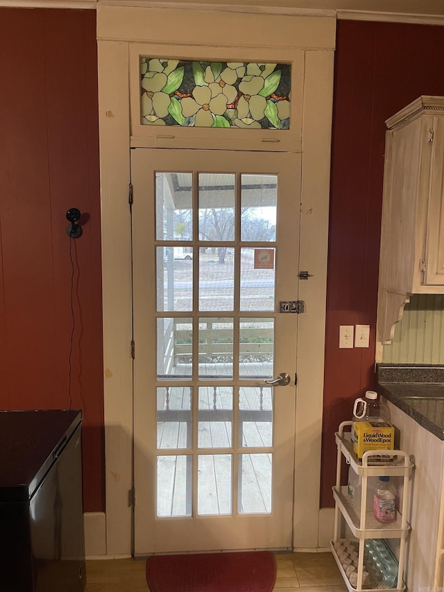 doorway with light tile patterned flooring