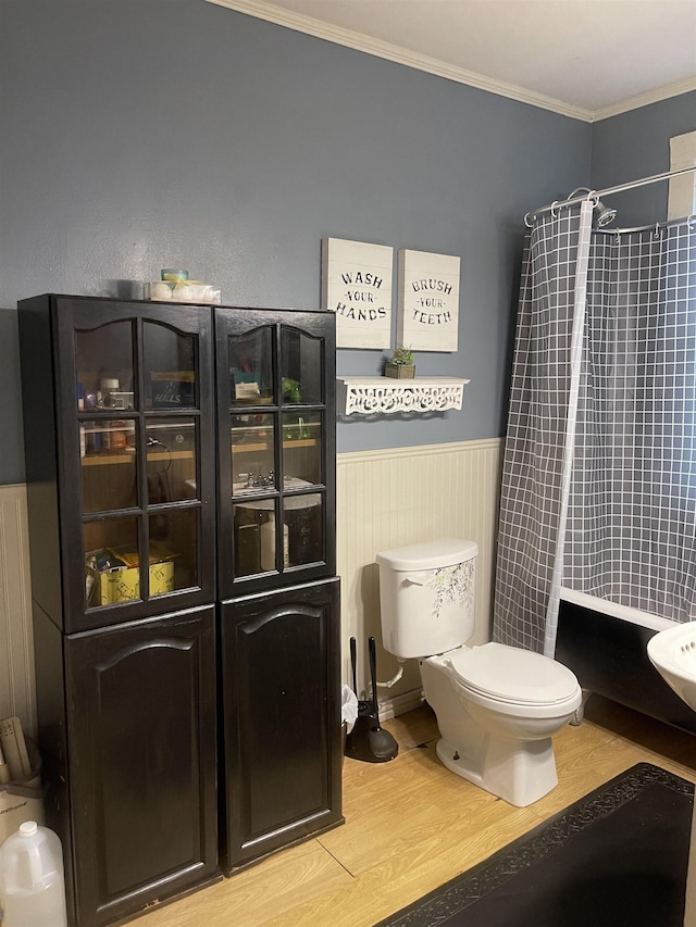 bathroom with toilet, crown molding, a shower with shower curtain, and hardwood / wood-style flooring