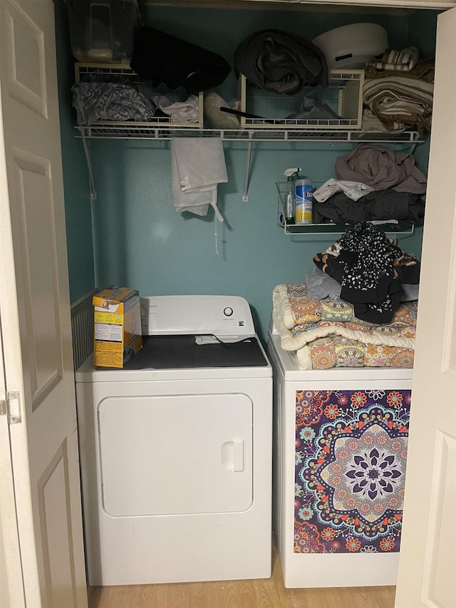 laundry area with washing machine and dryer and hardwood / wood-style flooring