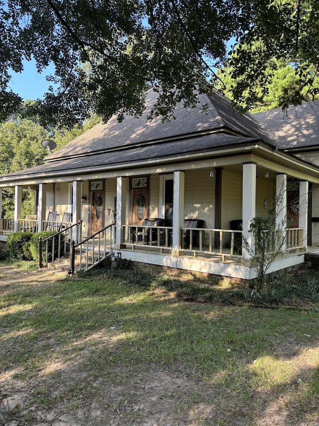 farmhouse inspired home featuring covered porch and a front lawn