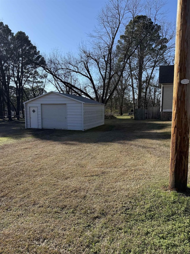 view of yard featuring a garage and an outbuilding