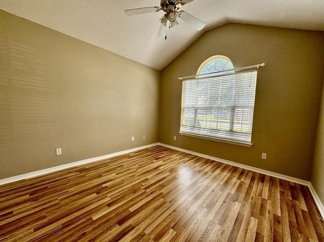 empty room featuring lofted ceiling, ceiling fan, and hardwood / wood-style flooring