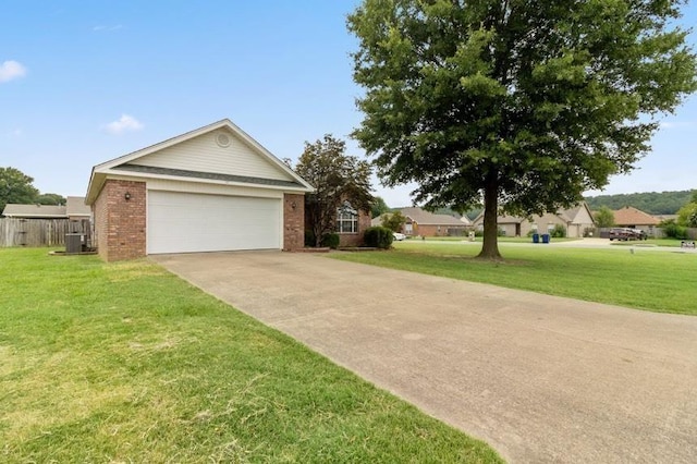 view of front of property featuring a garage, a front yard, and central air condition unit