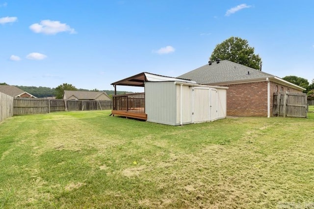 view of yard featuring a wooden deck and a storage unit