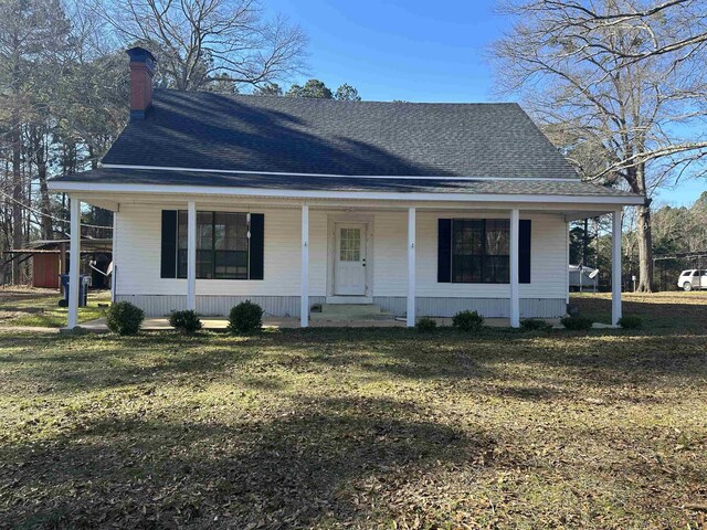 view of front of house featuring covered porch and a front yard