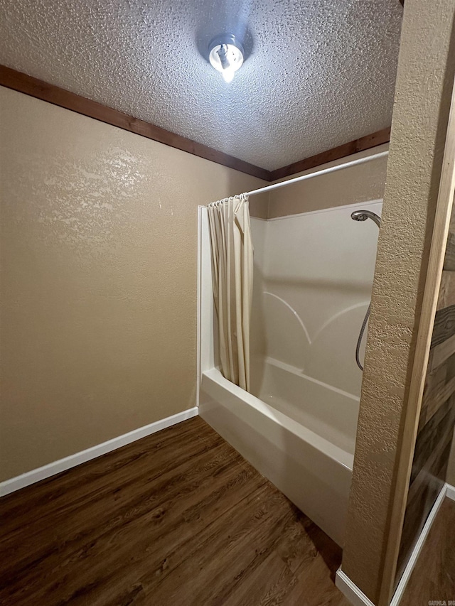 bathroom featuring a textured ceiling, shower / bath combo, and hardwood / wood-style floors