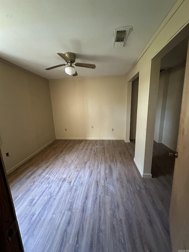 spare room with ceiling fan, dark wood-type flooring, and ornamental molding