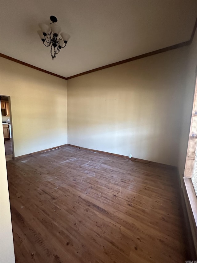 unfurnished room with dark hardwood / wood-style floors, ornamental molding, and an inviting chandelier