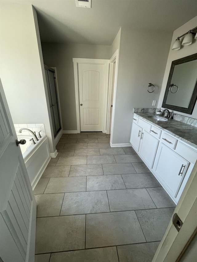 bathroom featuring tile patterned floors, vanity, and a tub