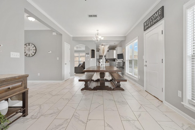 dining space featuring a chandelier and ornamental molding