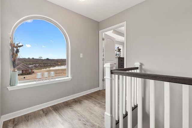 hall with a water view and light wood-type flooring